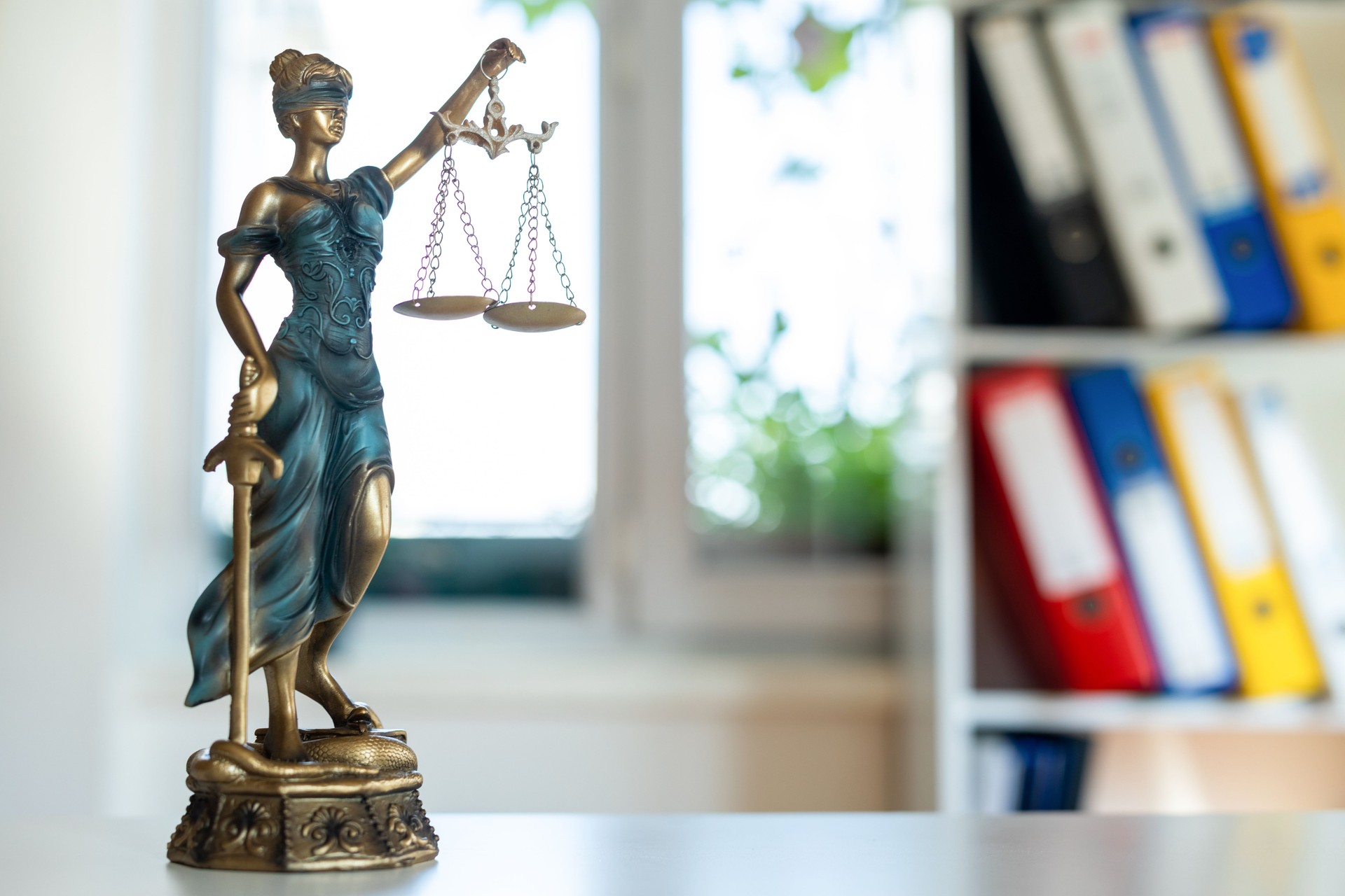 Law figure justice statue in office with bookshelf